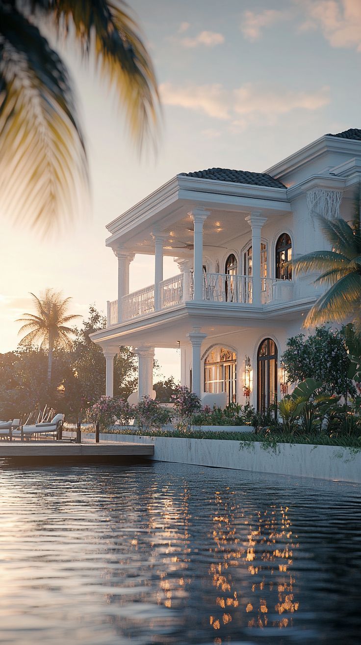 Luxury villa exterior with infinity pool reflecting the ocean at sunset