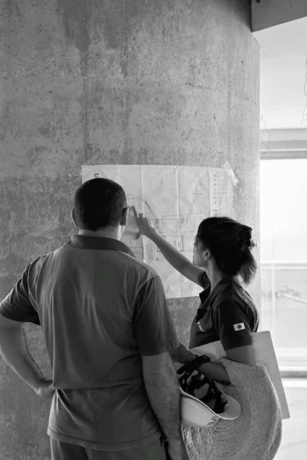 Black-and-white photo of two people looking outside, modern interior setting